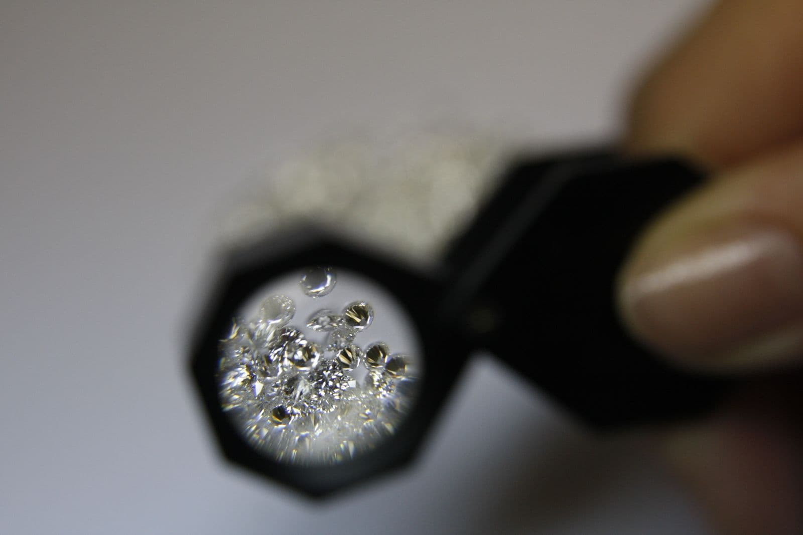 A gemologist examining diamonds through a loupe