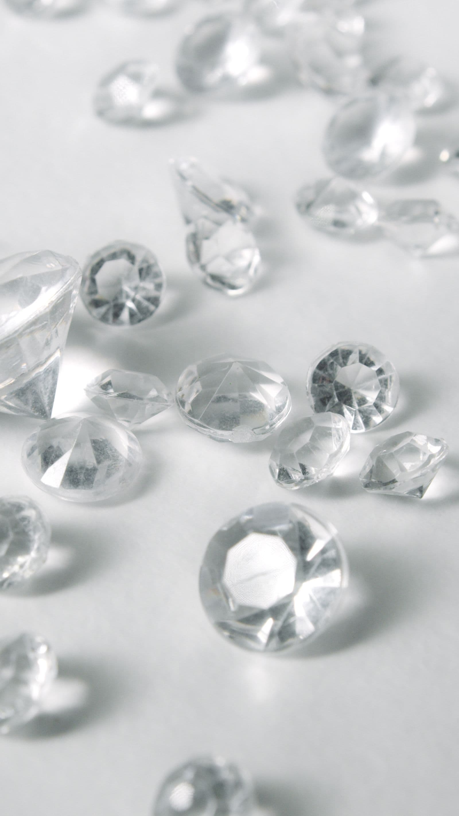 Loose diamonds scattered on a white surface